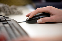 Business woman using mouse and computer.